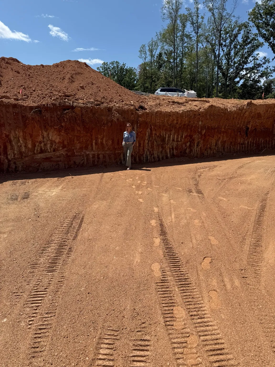 Mary Kate standing beside the excavated foundation of the Smith Mountain Lake home