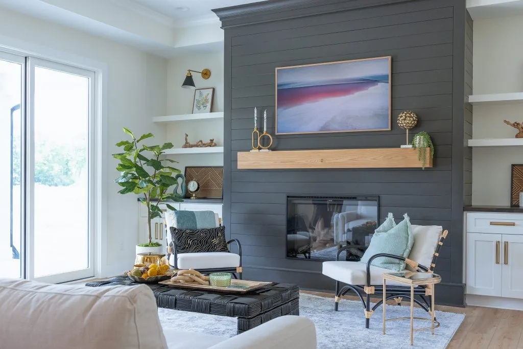 Smith Mountain Lake living room with a dark fireplace wall, wood mantel, and layered seating
