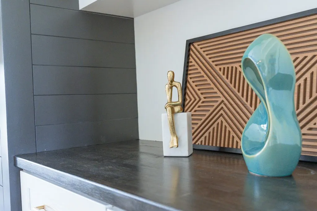 Sculptural objects and geometric wood artwork, styled on dark cabinetry